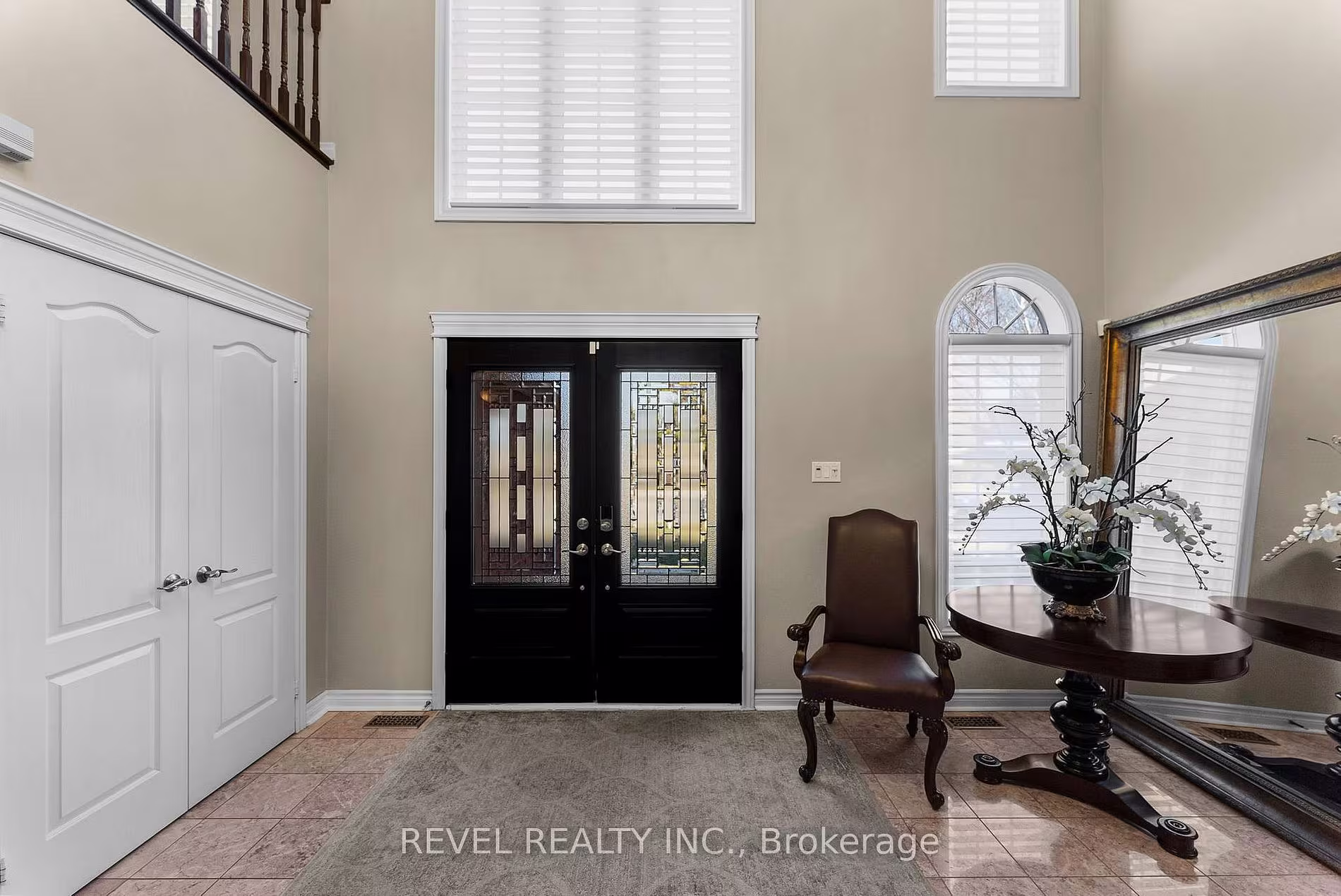 Two-storey foyer at 1486 Ashwood Gate, Pickering, with a round entry table and leather armchair, listed by The Gordon Brothers Team, Revel Realty Inc., Brokerage